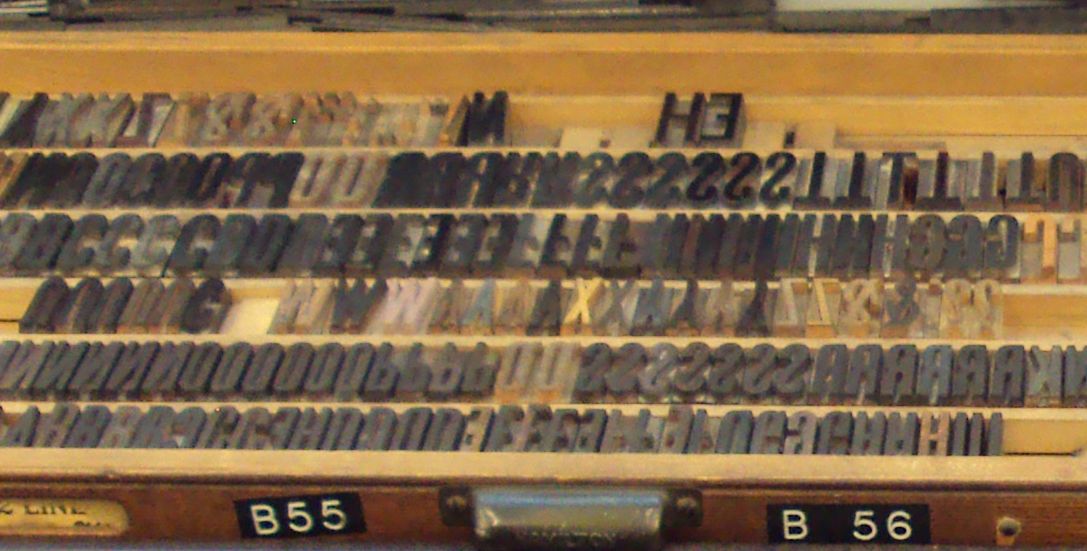 A compositor's type case seen from above, filled with rows of metal letter sorts.